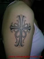 Tatuaje de una cruz en el brazo de una mujer