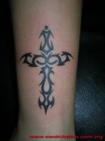 Tatuaje de una cruz hecha de tribales