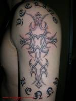 Tatuaje de una cruz hecha de tribales en reliebe