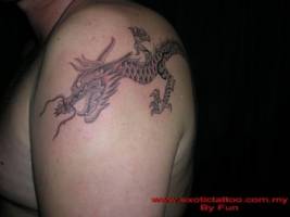 Tatuaje de un dragón que  acaba en el hombro
