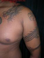 Tatuaje de un dragón enroscado en el brazo