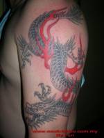 Tattoo de un dragón bajando entre el fuego por el brazo
