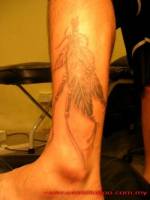 Tatuaje de un collar de plumas india en la pierna