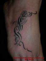 Tatuaje de una rosa con un tribal en el pie