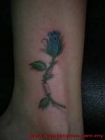 Tatuaje de una rosa atravesando la piel