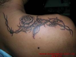 Tatuaje de una rosa enredada a un alambre de espinos