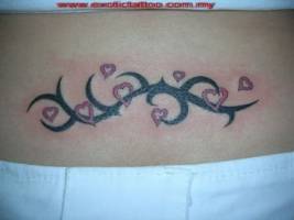 Tatuaje de un tribal rodeado de corazones