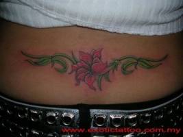 Tatuaje de una flor con hojas encima del culo