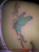 Tatuaje de una mariposa a color en la espalda de una mujer