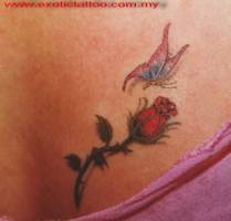 Tatuaje de una mariposa volando hacia una flor