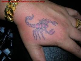 Tatuaje de un escorpión a color en la mano