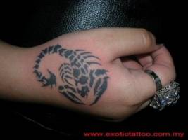 Tatuaje de un escorpión en la mano