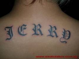 Tatuaje de un nombre en la espalda con letras góticas