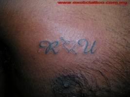 Tatuaje de dos iniciales con un corazón enmedio