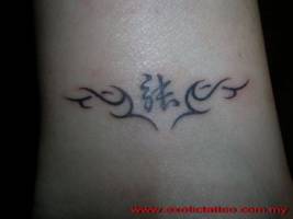 Tatuaje de un tribal con una letra china dentro