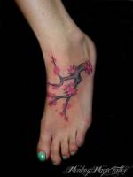 Tatuaje de una rama florida en el pie