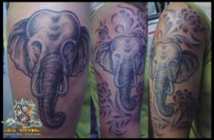 Tatuaje de una cabeza de elefantes con algunas flores
