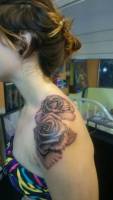 Tatuaje de dos rosas en los hombros de una chica