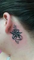 Tatuaje de una estrella de cinco puntas y una cinta detrás de la oreja de una chica