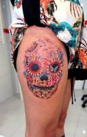 Tatuaje de una calavera mexicana hecha a base de flores y mariposas