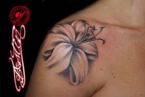 Tatuaje de una flor en blanco y negro en el hombro de una chica