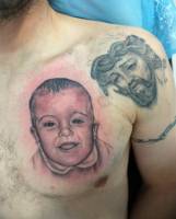 Tatuaje de un bebe en el pecho y un cristo en el hombro