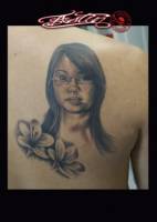 Tattoo retrato de una chica con un par de flores
