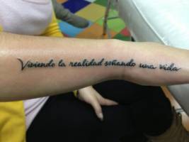 Frase tatuada en el brazo y mano de una chica