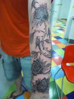 Tatto del brazo rodeado por rosas con espinas