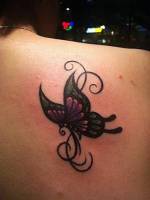 Tatuaje para mujeres, una mariposa con un fino tribal detrás