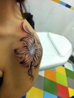Tattoo de una flor en el hombro de una chica