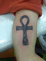Brazo tatuado con una cruz ansada egipcia