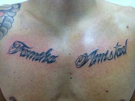 Tatuaje de las palabras familia y amistad en el pecho