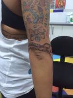 Tatuaje de un ancla un lazo y una cadena en el brazo