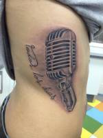 Tatuaje de un micrófono y una frase
