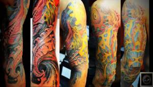 Tatuaje de piel alienígena y engranajes en el brazo