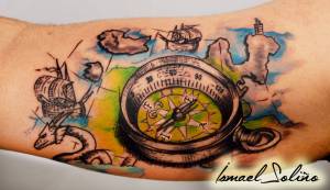 Tatuaje de una brújula encima de un mapa
