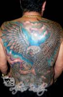 Tatuaje en la espalda de un águila luchando contra una serpiente