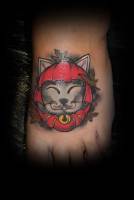 Tattoo de la cabeza de un gato chino de la suerte en el pié