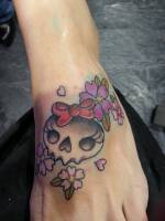 Tatuaje de una calavera con lazo y varias con flores