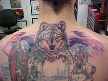 Tatuaje de paisaje, con indios y cabeza de lobo