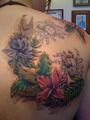 Tatuajes de tarantulas y flores en la espalda