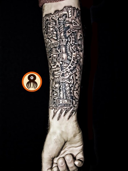 Tatuaje de piel desgarrada mostrando todo el antebrazo lleno de engranajes y mecanismos