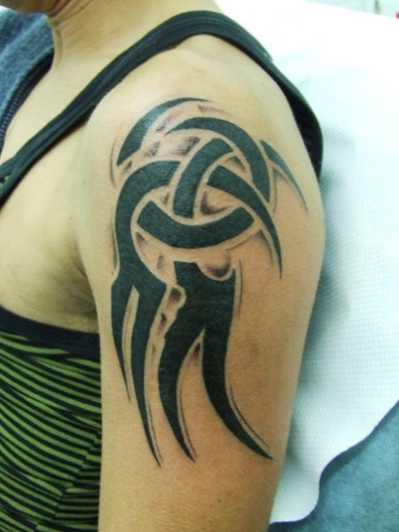 Tatuaje de un tribal en el brazo de una mujer