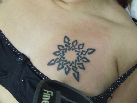 Tatuaje del sol encima del pecho de una chica