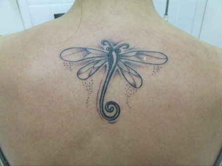 Tatuaje de una gran libélula en la espalda