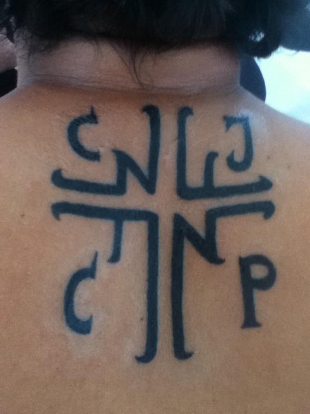 Tatuaje de una cruz con las letras C J C P