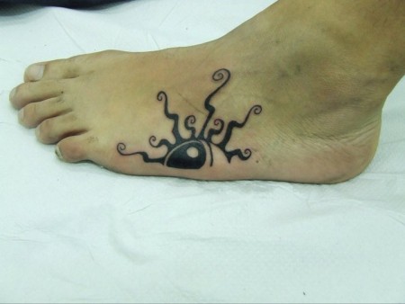 Tatuaje de medio sol en el pie. La pareja tiene la otra mitad