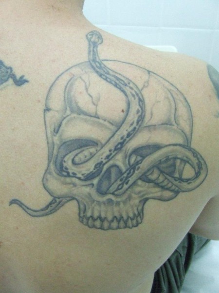 Tatuaje de una calavera con una serpiente saliendo por su ojo