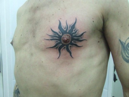 Tatuaje de un sol en el pezón
